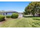 Spacious backyard with lawn, mature trees/landscaping and view of the screened lanai at 1416 Leland Dr # 49, Sun City Center, FL 33573