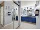 Bathroom features blue cabinets, double sinks, a large mirror, and tiled shower at 1416 Leland Dr # 49, Sun City Center, FL 33573