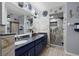 Bathroom features blue cabinets, double sinks, a large mirror, and tiled shower at 1416 Leland Dr # 49, Sun City Center, FL 33573