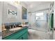 Well-lit bathroom featuring a turquoise vanity with granite countertop and tub/shower combo with decorative glass doors at 1416 Leland Dr # 49, Sun City Center, FL 33573