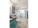 Nicely decorated bathroom with tub/shower combo featuring decorative glass doors, and a turquoise vanity with granite countertop at 1416 Leland Dr # 49, Sun City Center, FL 33573