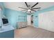 Bright bedroom with blue walls, wood-look floors, large ceiling fan and a white dresser with shelving at 1416 Leland Dr # 49, Sun City Center, FL 33573