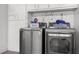 Bright laundry room with front loading stainless steel washer and dryer and custom cabinets at 1416 Leland Dr # 49, Sun City Center, FL 33573