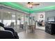 Bright sunroom featuring floor-to-ceiling windows, modern lighting, dining area and view into office at 1416 Leland Dr # 49, Sun City Center, FL 33573