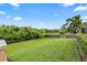 Lush green backyard with mature trees and a wooden fence, perfect for outdoor enjoyment at 16804 Windsor Park Dr, Lutz, FL 33549