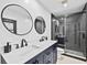 Modern bathroom boasts double vanity, sleek fixtures, and glass-enclosed shower at 16804 Windsor Park Dr, Lutz, FL 33549