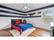 Cozy bedroom with hardwood floors, ceiling fan, and whimsical baseball themed decor at 16804 Windsor Park Dr, Lutz, FL 33549