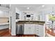 Modern kitchen with stainless steel appliances, island sink, and open view to the living space at 16804 Windsor Park Dr, Lutz, FL 33549