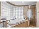 Bright main bathroom with glass block window above tub and frameless glass shower enclosure at 16804 Windsor Park Dr, Lutz, FL 33549