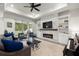 Cozy living room featuring a stone fireplace, built-in shelves, tray ceilings, and sliding glass doors to the backyard at 20764 Monza Loop, Land O Lakes, FL 34638