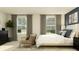 Serene main bedroom with large windows, stylish decor, and comfortable seating area at 208 27Th Se St, Ruskin, FL 33570