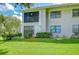Condo backyard showcasing a well-maintained lawn and screened-in balcony at 2139 Elm St # 308, Dunedin, FL 34698