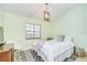 A simple bedroom featuring natural light, a cozy bed, and neutral green walls at 2139 Elm St # 308, Dunedin, FL 34698