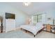 Bright bedroom featuring a comfortable bed, dresser with TV, and ample natural light from the window at 2139 Elm St # 308, Dunedin, FL 34698