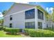 Condo exterior featuring neutral tones, screened balconies and surrounded by lush greenery at 2139 Elm St # 308, Dunedin, FL 34698
