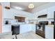 Bright kitchen with white cabinets, black appliances, modern countertops, and a window view to the dining area at 2139 Elm St # 308, Dunedin, FL 34698