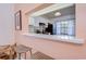 Open kitchen featuring light countertops, cabinetry, and barstool seating with a view through a pink frame into a dining area at 2139 Elm St # 308, Dunedin, FL 34698