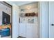 Convenient laundry closet with stacked washer and dryer units, shelving for storage, and easy access within the home at 2139 Elm St # 308, Dunedin, FL 34698