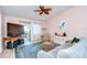Stylish living room featuring a comfortable sofa, blue rug, and sliding glass doors to a patio, with a ceiling fan at 2139 Elm St # 308, Dunedin, FL 34698