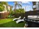 Private backyard oasis featuring a grill, lounge chairs, artificial turf, and a modern fence for outdoor enjoyment at 2505 W Azeele St, Tampa, FL 33609