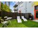 Backyard featuring artificial turf, two lounge chairs and a small patio set at 2505 W Azeele St, Tampa, FL 33609