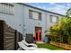 View of the backyard, showcasing the synthetic grass, lounge chairs, and rear facade with orange door at 2505 W Azeele St, Tampa, FL 33609