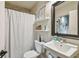 A clean and functional bathroom with a white shower curtain, toilet, sink, and a large mirror at 2505 W Azeele St, Tampa, FL 33609