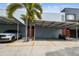 Modern condo with covered parking, palm trees, and vibrant orange entry doors; convenient and stylish living at 2505 W Azeele St, Tampa, FL 33609