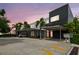Modern condo featuring covered parking, bright orange doors, and lush tropical landscaping at dusk at 2505 W Azeele St, Tampa, FL 33609