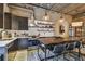 Kitchen with modern cabinetry, stainless steel appliances, concrete block walls, open shelving, and dining table at 2505 W Azeele St, Tampa, FL 33609