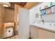 Bright laundry room features modern washer and dryer, shelving, and convenient access to the upper and lower floors of the home at 2505 W Azeele St, Tampa, FL 33609