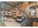 Open-concept living space with exposed brick walls, metal staircase and ductwork, with modern furnishings and decor at 2505 W Azeele St, Tampa, FL 33609
