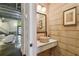 Hallway view of powder room with vessel sink, decorative mirror, and accent wall at 2505 W Azeele St, Tampa, FL 33609