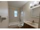 Tiled bathroom featuring a shower-tub combo, single sink vanity, and tiled walls at 2713 W Chestnut St, Tampa, FL 33607