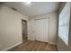 A bedroom with a closet, wood-look floors, neutral walls, and natural light at 2713 W Chestnut St, Tampa, FL 33607