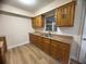 Traditional kitchen featuring wood cabinets, double sink, and new floors at 2713 W Chestnut St, Tampa, FL 33607