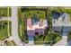 Aerial view of a home with a pool and well-maintained landscaping and a pink roof at 2886 Green Meadow Ct, Clearwater, FL 33761