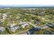 Aerial view of a pink-roofed home nestled in a lush, green neighborhood with a nearby golf course at 2886 Green Meadow Ct, Clearwater, FL 33761