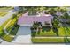 Aerial view of the landscaped home with a pink tile roof, lush lawn, and a spacious driveway at 2886 Green Meadow Ct, Clearwater, FL 33761