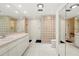 Bright bathroom with a glass block shower and mirrored walls, plus a large vanity with dual sinks at 2886 Green Meadow Ct, Clearwater, FL 33761