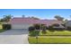 Charming single-story home featuring a unique pink roof and well-maintained landscaping at 2886 Green Meadow Ct, Clearwater, FL 33761