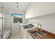 Functional laundry room with stainless steel sink and ample storage at 2886 Green Meadow Ct, Clearwater, FL 33761
