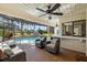 Relaxing outdoor seating area with a bar, ceiling fans, and a view of the screened pool at 2886 Green Meadow Ct, Clearwater, FL 33761