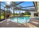 Beautiful screened pool featuring a small waterfall and tropical landscaping at 2886 Green Meadow Ct, Clearwater, FL 33761