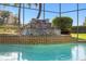 Close-up view of the waterfall feature in the screened pool with tiled accents at 2886 Green Meadow Ct, Clearwater, FL 33761
