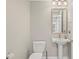Neutral powder room features a pedestal sink, decorative mirror and modern lighting fixture at 300 Beach Ne Dr # 401, St Petersburg, FL 33701