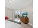 Bedroom with a slider door to a balcony and dresser with beach scene television at 300 Beach Ne Dr # 401, St Petersburg, FL 33701
