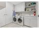 Functional laundry room with washer, dryer, sink, and ample cabinet space for storage at 300 Beach Ne Dr # 401, St Petersburg, FL 33701