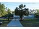 Exterior view of a fenced home featuring a palm tree and well-kept lawn at 3421 E Powhatan Ave, Tampa, FL 33610