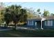 View of home with fenced yard and mature landscaping at 3421 E Powhatan Ave, Tampa, FL 33610